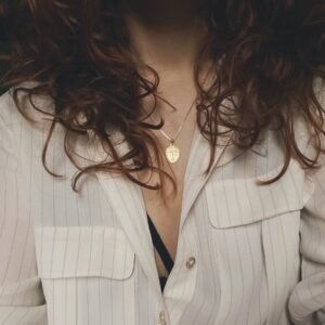 woman in white blazer with silver necklace