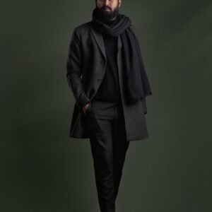 a man in a black suit and scarf